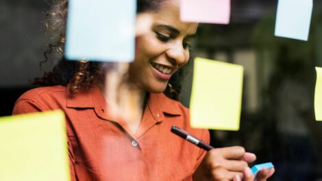 Person using sticky notes to keep track of ideas on a board.