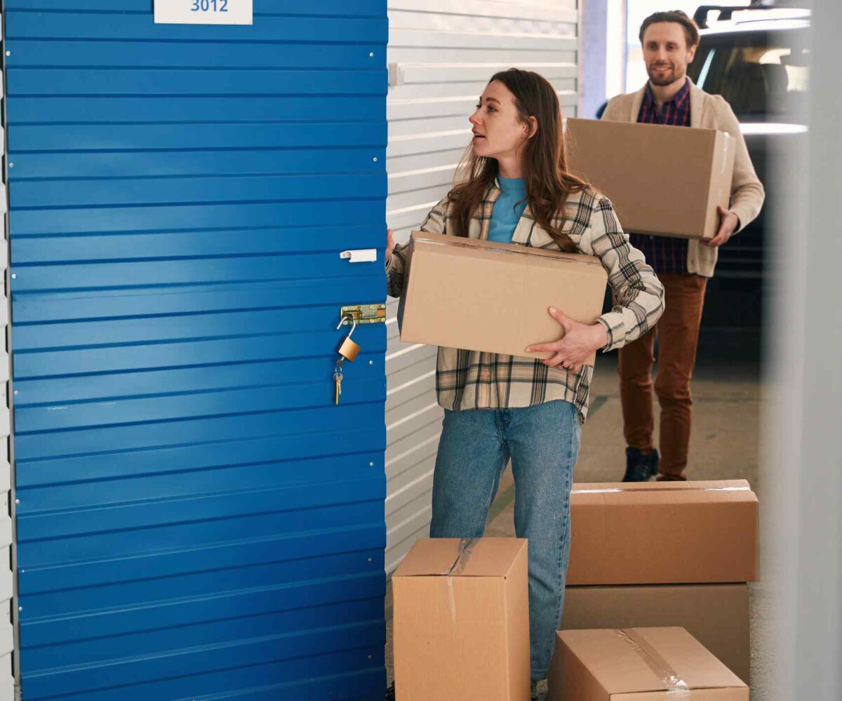 Father helps daughter move boxes into a storage unit.
