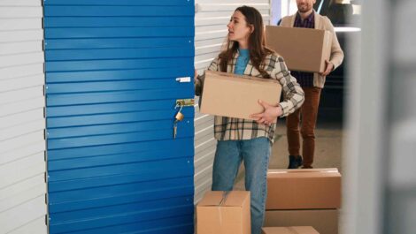 Father helps daughter move boxes into a storage unit.