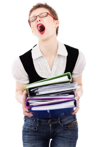 A stressed woman holding binders.