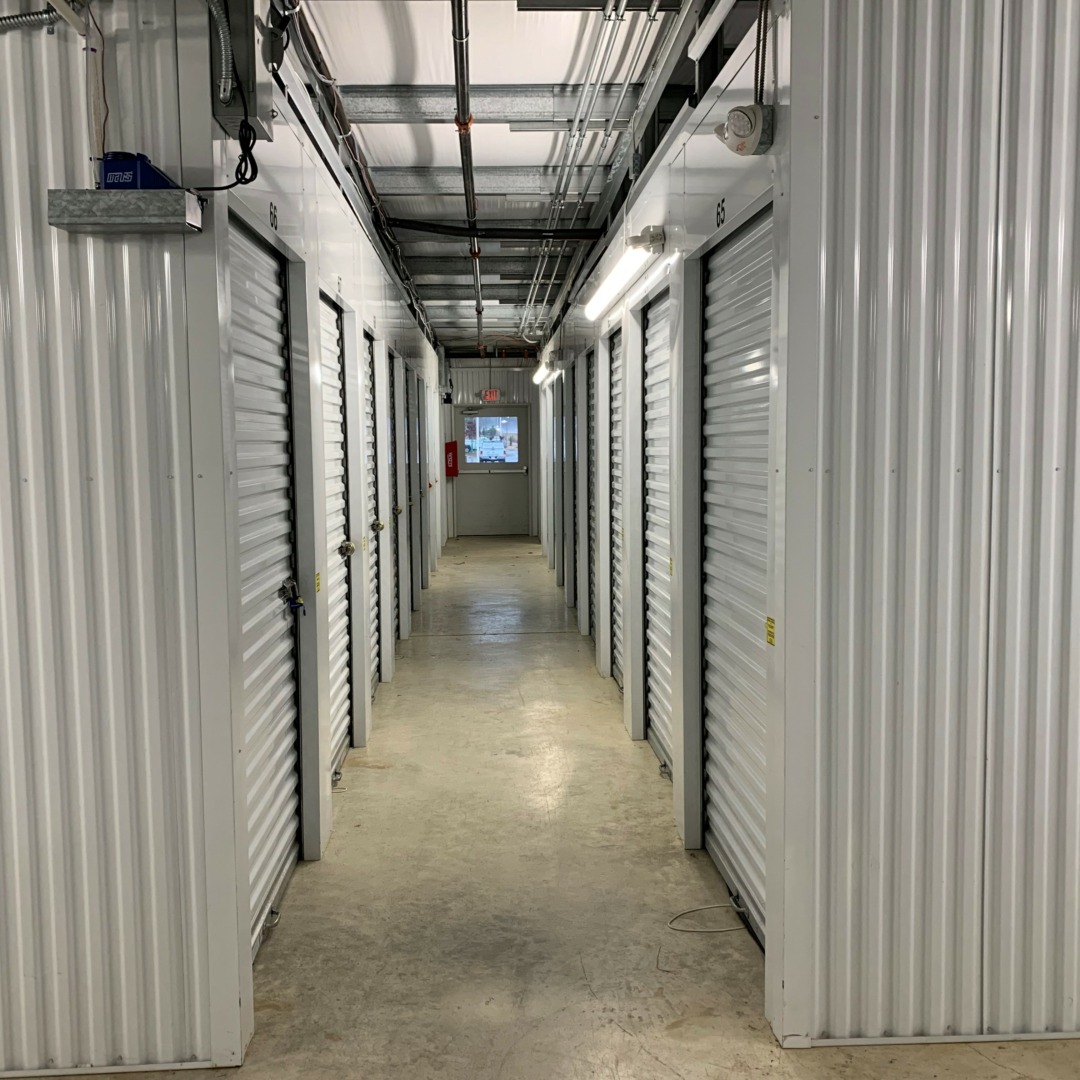Hallway of interior storage units with roll-up doors.