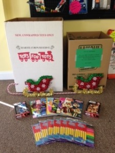 Toys for tots boxes with coloring books and markers on the ground.