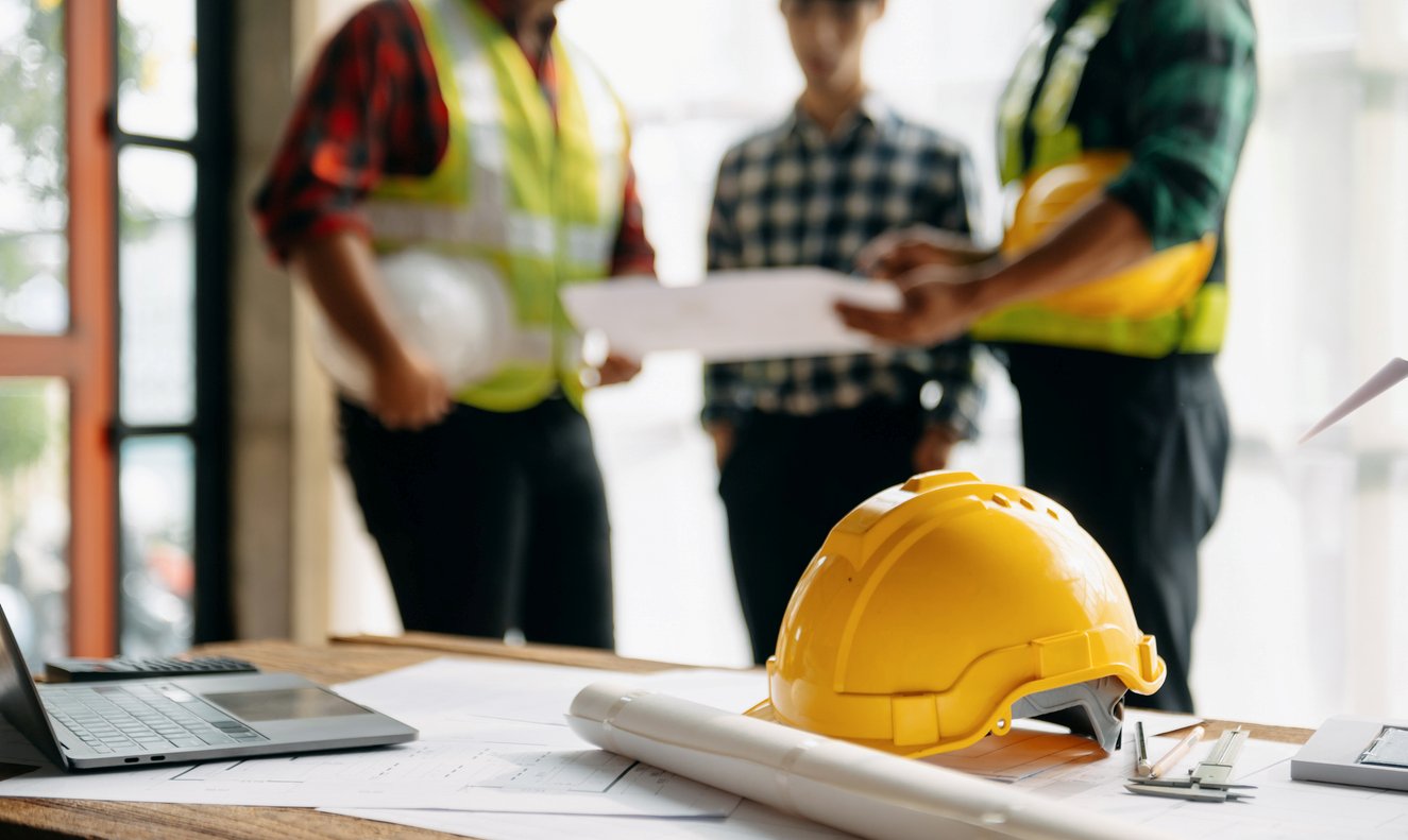 A manager flanked by two contractors going over renovation plans.