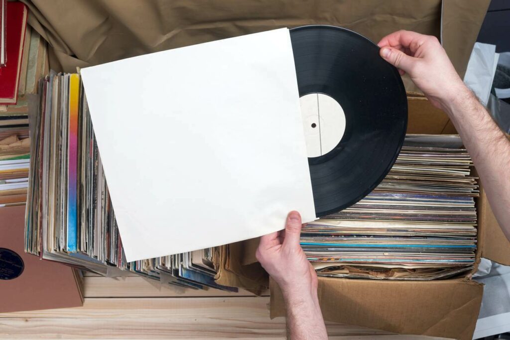 A person pulls a vinyl record out of its sleeve
