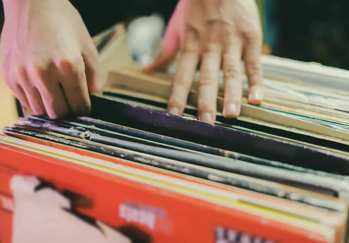 A person sorts through a stack of vinyl records