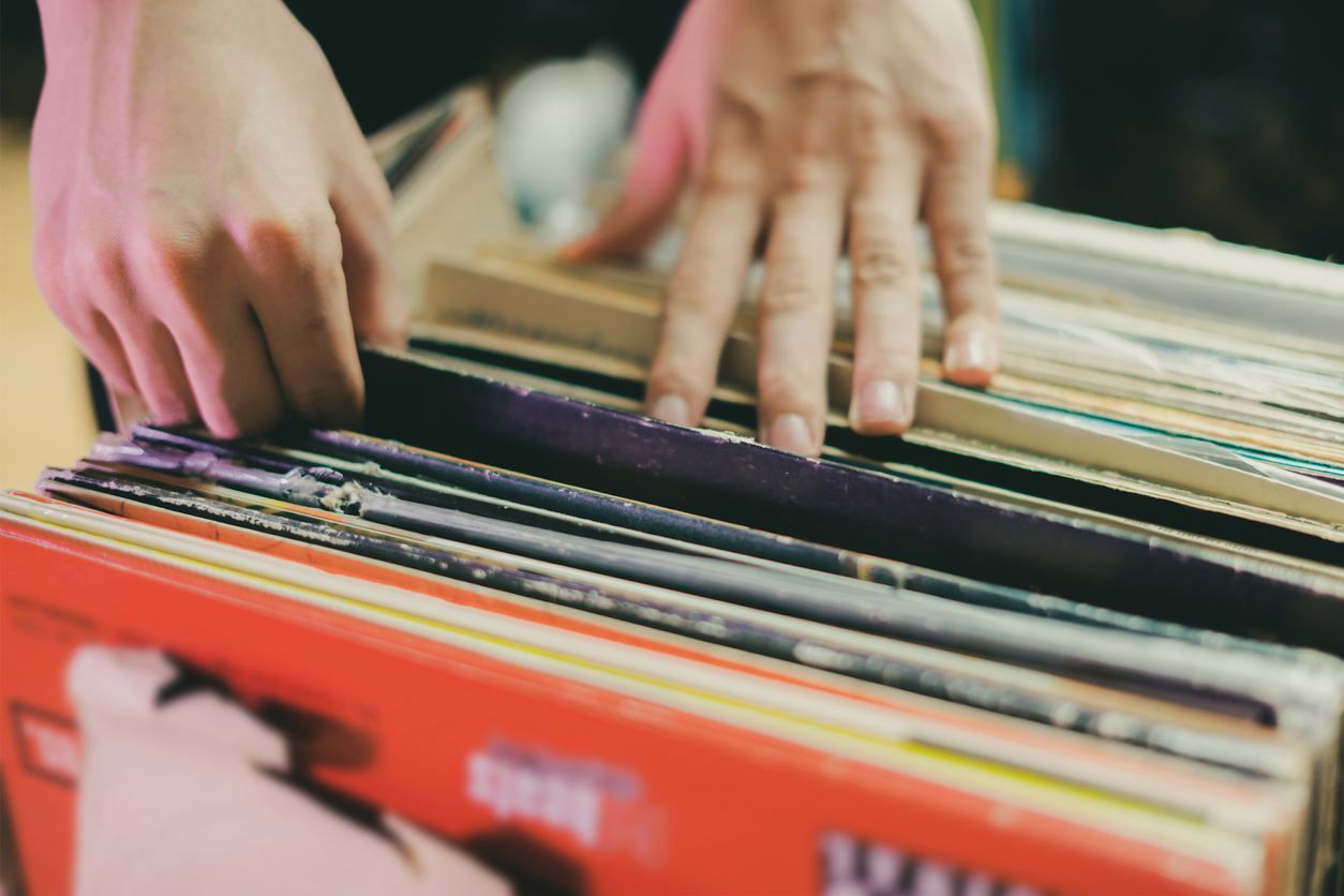 A person sorts through a stack of vinyl records