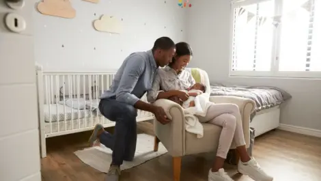 Parents sit with a baby in a nursery
