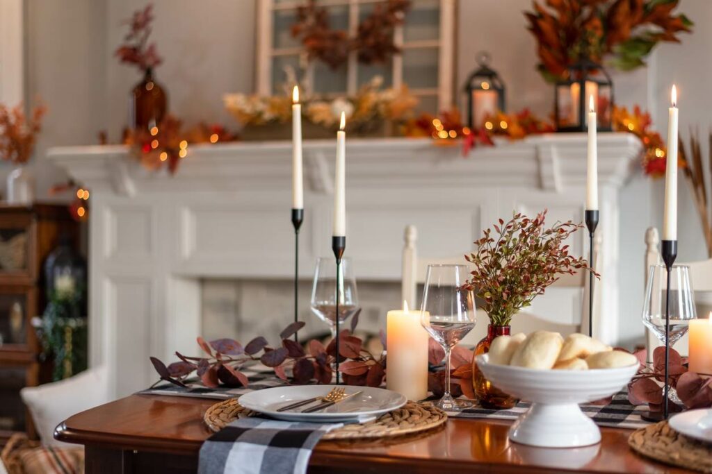 A table is set for Thanksgiving with candles and cozy decor