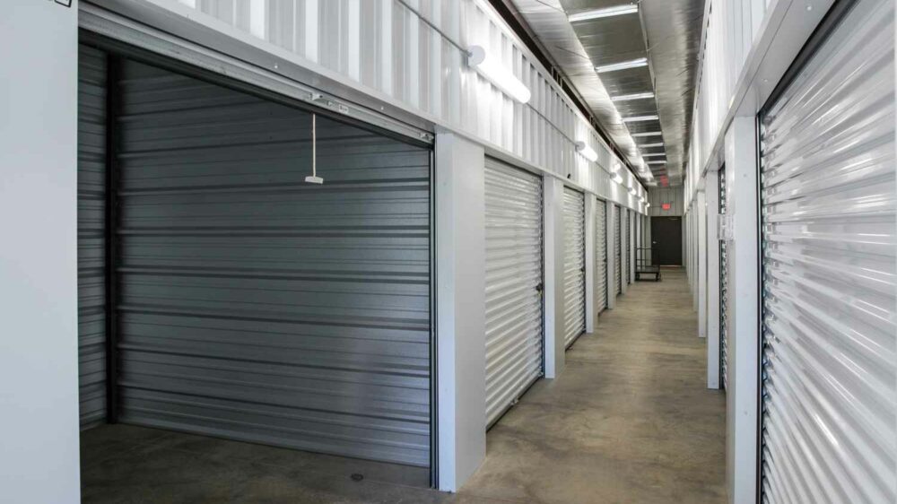 A row of interior storage units with white roll-up doors.