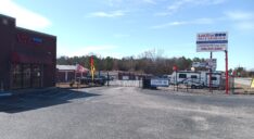 The exterior of the leasing office at LokStar Self Storage with customer parking and facility access gate.