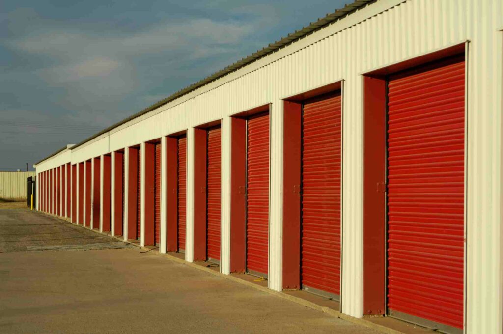 A row of outdoor storage units with red doors
