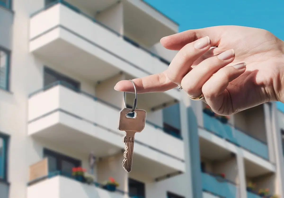 A woman holds a key in front of a vacation property