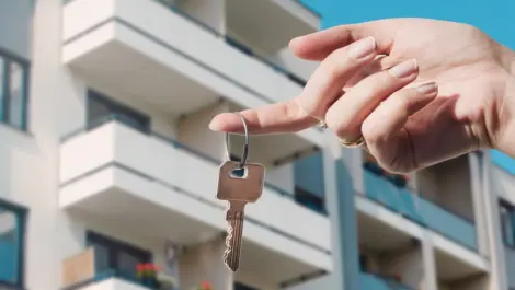 A woman holds a key in front of a vacation property