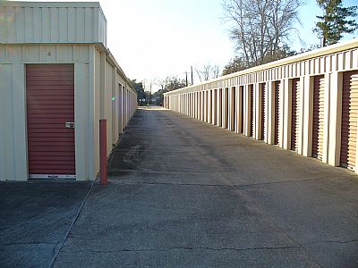 An aisle of drive-up access storage units with roll-up doors.