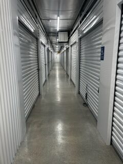 A hallway of interior storage units with roll-up access doors.