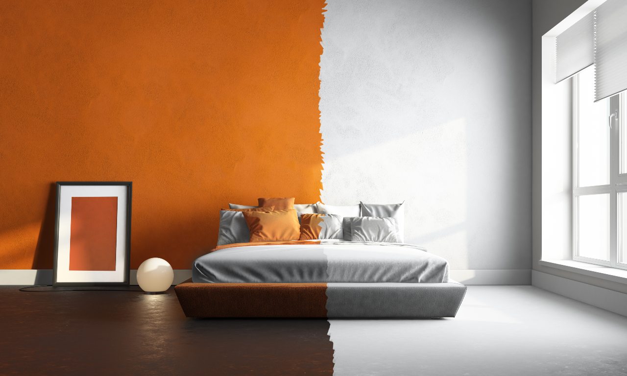 A bedroom with one-half orange walls, dark flooring, and extra décor and one-half white walls, white bedding, and floors with no extra décor