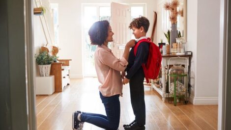 A child and his mother get ready for him to go back to school.