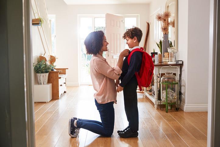 A child and his mother get ready for him to go back to school.