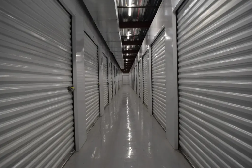 Hallway view of white indoor storage units.