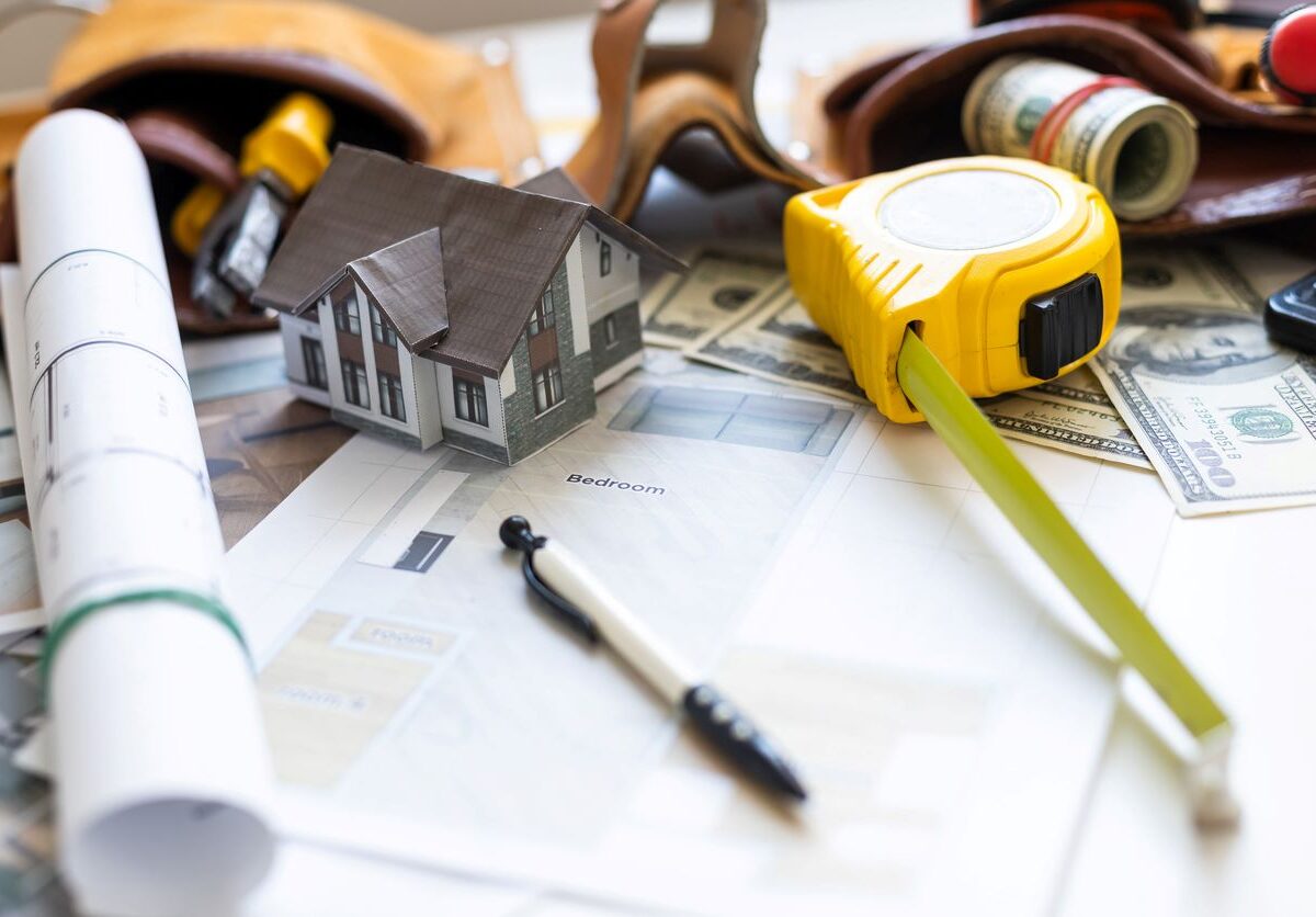 A model house on blueprints with keys to the new home for upcoming spring renovations.