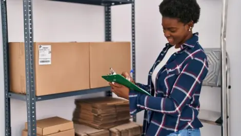 A woman taking inventory on a clipboard in her self-storage unit.